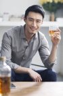 Азиатский мужчина наслаждается алкогольным напитком — стоковое фото