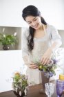 Donna cinese che organizza fiori a casa — Foto stock