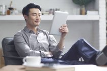 Homem asiático usando tablet digital no escritório — Fotografia de Stock