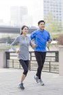 Mature chinese couple jogging in park — Stock Photo