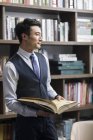 Asian businessman reading book in study — Stock Photo