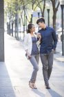 Couple chinois tenant la main tout en marchant sur le trottoir — Photo de stock