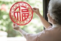Senior woman with Chinese New Year paper-cut — Stock Photo