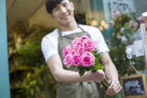 Fleuriste chinois tenant bouquet de fleurs — Photo de stock