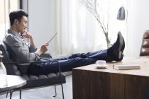 Asiatique homme utilisant tablette numérique dans le bureau — Photo de stock