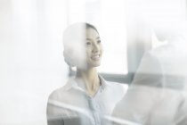 Chinese businesswoman and businessman talking in office — Stock Photo