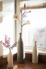 Vases with flowers on window sill — Stock Photo