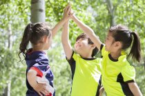 Chinese children in sportswear high fiving — Stock Photo