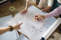 Architects working on blueprints at office table — Stock Photo