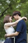 Joven pareja china abrazándose en el parque - foto de stock