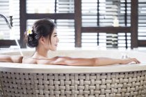 Задній вид молода Китайська жінка, що у ванній — стокове фото