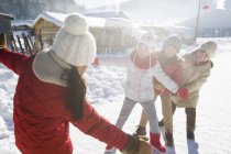 Niños de edad elemental chinos jugando en la nieve en la aldea - foto de stock