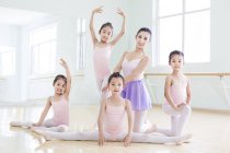 Chinesischer Ballettlehrer posiert mit Mädchen im Ballettstudio — Stockfoto