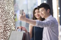 Couple chinois prenant selfie tout en faisant du shopping — Photo de stock