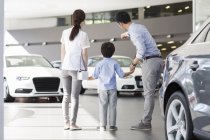 Chinesische Familie zeigt in Autohaus-Showroom auf Autos — Stockfoto