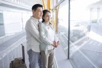 Зрелая китайская пара ждет в аэропорту — стоковое фото