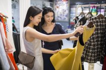 Китайський подруг, дивлячись на плаття в магазин одягу — стокове фото