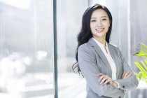 Mujer de negocios asiática con los brazos cruzados - foto de stock