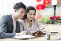 Menu de lecture couple chinois au restaurant — Photo de stock