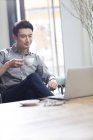 Asiatico uomo working con laptop e caffè in ufficio — Foto stock