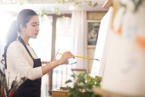 Asian woman painting in art studio — Stock Photo