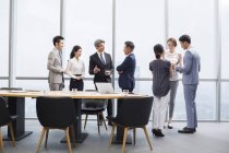 Chinese business team having meeting with foreign partners in board room — Stock Photo
