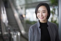 Retrato de mujer asiática sonriendo y mirando hacia otro lado - foto de stock