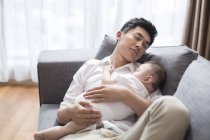 Китайский отец и малыш спят вместе на диване — стоковое фото
