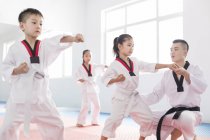 Instructor chino enseñando a los niños Taekwondo - foto de stock