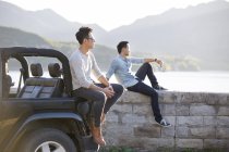 Chinese men resting on lakeside in suburbs — Stock Photo