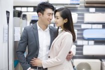 Chinese couple buying air conditioner in electronics store — Stock Photo