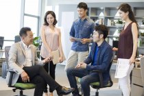 Команда китайских бизнесменов обсуждает работу на совещании — стоковое фото