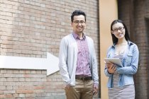 Asiatische Mann und Frau lächeln und suchen in der Kamera auf der Straße — Stockfoto