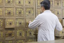 Rear view of chinese doctor in traditional medicine pharmacy — Stock Photo