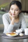 Nahaufnahme einer asiatischen Frau beim Frühstück zu Hause — Stockfoto