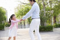 Asiático pai e filha girando ao redor no parque — Fotografia de Stock