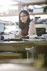 Arquiteta feminina sentada à mesa no escritório e sorrindo — Fotografia de Stock