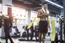 Chinese ruht sich mit Handtuch im Fitnessstudio aus — Stockfoto