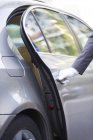 Cropped view of chauffeur opening car door — Stock Photo