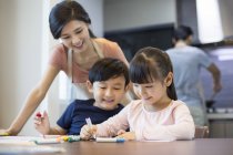Chinese siblings drawing together at home — Stock Photo