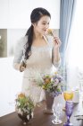 Donna cinese che organizza fiori a casa — Foto stock