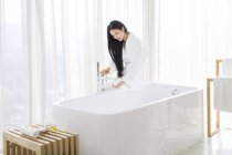 Donna cinese che riempie vasca da bagno con acqua — Foto stock
