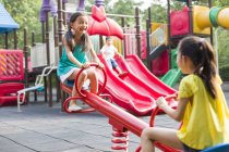 Китайские девочки играют на детской площадке — стоковое фото