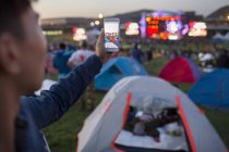 Hombre chino tomando fotos con smartphone en el festival de música - foto de stock