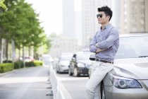 Китаєць, спираючись на автомобіль — стокове фото