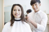 Chinese barber cutting customer hair — Stock Photo