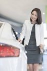 Chinesin wählt Auto im Showroom — Stockfoto
