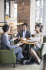 Asiáticos de negocios teniendo reunión en la cafetería - foto de stock