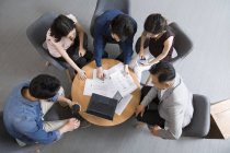 Gente de negocios chinos hablando en reunión con el ordenador portátil, vista aérea - foto de stock