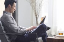Молодой человек, работающий с ноутбуком в офисе — стоковое фото